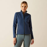 Woman wearing a blue jacket and grey leggings on a beige background